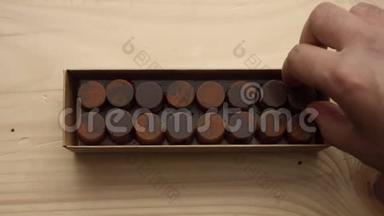 巧克力糖果盒的特写和一个男人`手拿起其中一个